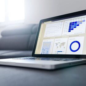Sleek laptop showing data analytics and graphs in a bright room.